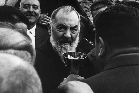 Father Pio walking among the faithful.