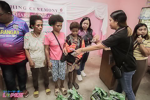 AETA women from Barangay Villa Espina, Lopez, Quezon receive sacks of rice from DSWD and Okada Foundation.