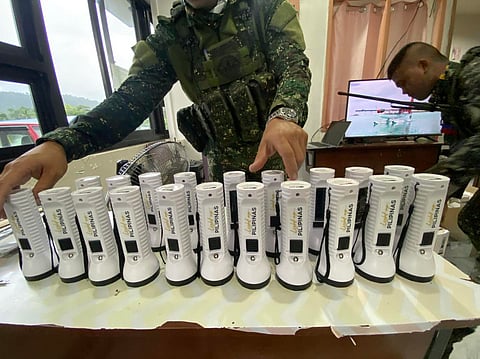 SOLAR lamps and torches (above) will light up homes of Tagbanua families. Meralco’s mascot hand school bags to students of General Roxas Elementary School (right).
