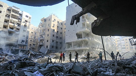 People walk amid the rubble of buildings levelled by Israeli strikes that killed Hezbollah leader Hassan Nasrallah in Beirut's southern suburbs, on September 29, 2024.