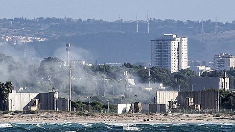 A cloud of smoke billows after missiles were fired from Israel's Iron Dome missile-defence system batteries to intercept rockets over the northern city of Acre on 1 October 2024.