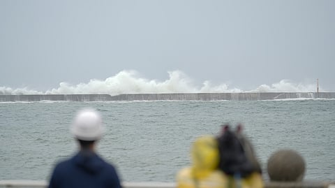 A TV crew films the sea at Sizihwan beach in Kaohsiung as super typhoon Krathon moves towards Taiwan on 1 October 2024.