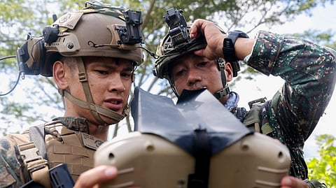 (FILES) U.S. Marine Corps Sgt. Vincent Tran, a communications chief with Marine Rotational Force-Southeast Asia, I Marine Expeditionary Force, shows a Philippine Marine with 3rd Marine Brigade, Philippine Marine Corps, aerial footage of an RQ-20B small unmanned aerial system at a sUAS subject matter expert exchange during KAMANDAG 7 in Iwahig, Palawan, Philippines, 13 November 2023.