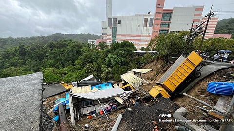 This handout photo taken and released on 4 October 2024 by Taiwanese city councilor Chen Yi shows public utility vehicles trapped in a landslide that was triggered by heavy rainfall after Typhoon Krathon swept across the island near Keelung City's Bureau of Environmental Protection.