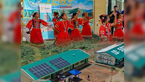 Solar panels on the roof of Gamot Integrated School in Quezon, Bukidnon. Students (top) perform during the turnover rite for the GIS electrification.