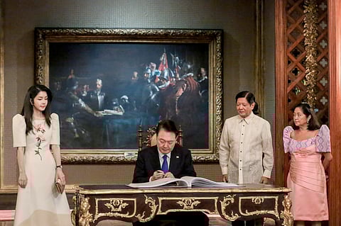 PRESIDENT Yoon Suk Yeol signs the Malacañang guest book as his wife, Kim Keon-hee, and President Ferdinand Marcos Jr. and First Lady Liza Araneta-Marcos look on.