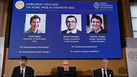 (L-R) Heiner Linke, chair of the Nobel Committee for Chemistry at the Royal Swedish Academy of Sciences, the Secretary General of the Royal Swedish Academy of Sciences Hans Ellegren and member of the Nobel Committee for Chemistry Johan Aqvist sit in front of a screen depicting the laureates (L-R) David Baker, Demis Hassabis and John M. Jumper of the 2024 Nobel Prize in Chemistry during the announcement by the Royal Swedish Academy of Sciences in Stockholm, Sweden on 9 October 2024.