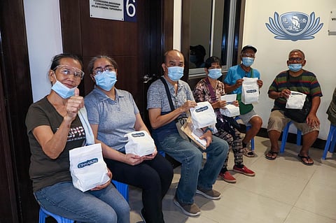 Patients at the Tzu Chi Eye Center in Sta. Mesa, Manila enjoy cinnamon rolls donated in loving memory of Arben Santos.