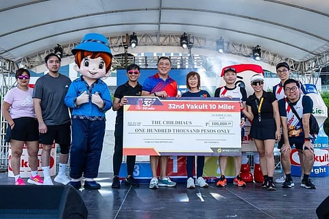 YAKULT Philippines vice president Michael Ong (center) presents a check of P100,000 to CHILD Haus representative Jeanette Cu (right) during the 32nd Yakult 10 Miler at the Mall of Asia Concert Grounds.