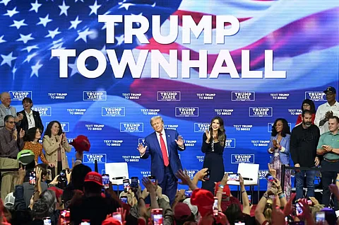 Former US President and Republican presidential candidate Donald Trump, with moderator and South Dakota Governor Kristi Noem (right), arrives for a town hall at the Greater Philadelphia Expo Center and Fairgrounds in Oaks, Pennsylvania, on October 14, 2024.