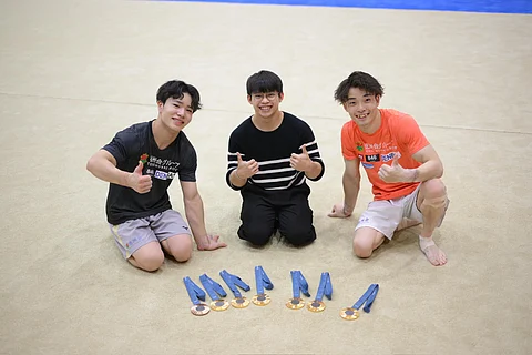 Carlos Yulo (middle) displays his Olympic gold medals with former clubmates Shinnosuke Oka (left) and Takaaki Sugino during his visit to the Tokushukai Gymnastics Club in Tokyo on Tuesday.