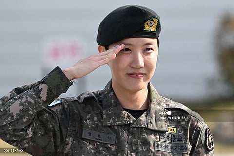BTS member J-hope salutes after being discharged from his mandatory military service outside a military base in Wonju on October 17, 2024. K-pop megastar J-hope from BTS ended eighteen months of South Korean military service on October 17, and hailed the "sacrifice" of soldiers working to keep the country safe, as fans wept for joy at his return to the industry.
JUNG YEON-JE / AFP