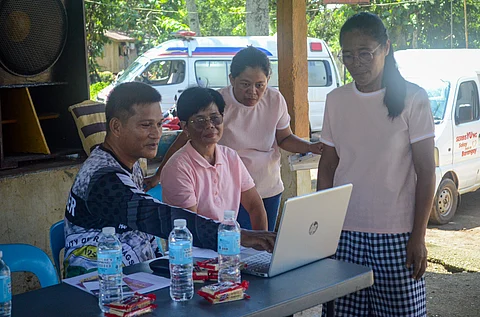 PROVINCIAL DRR officer Noriben Jay Lubguban (left) shows hazard map on a laptop computer to women residents of Barangay Sto. Rosario, Ramon Magsaysay town.