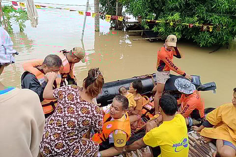 This handout photo taken and released yesterday by the Philippine Coast Guard shows residents affected by tropical storm ‘Kristine’ being evacuated from the roofs of their submerged houses in Libon town, Albay. Rescuers waded through chest-deep floodwaters to reach residents trapped by the storm, which has forced thousands to evacuate as it barrels towards the country's east coast.