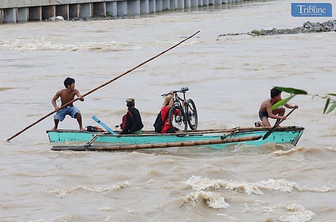LOOK: Residents of San Mateo, Rizal, are seen risking their lives on Thursday, 24 October, as they attempt to cross the swollen San Mateo River, flooded by Tropical Storm Kristine's heavy rains.