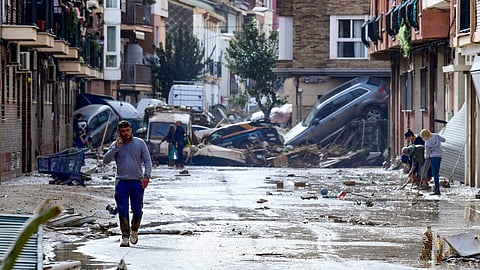 Residents are pictured next to cars piled in a street covered in mud following floods in Picanya, near Valencia, eastern Spain, on October 30, 2024. Floods triggered by torrential rains in Spain’s eastern Valencia region has left 51 people dead, rescue services said on October 30.