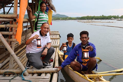 One Meralco Foundation (OMF), through its program Light Up Pilipinas, has donated solar lamps for fisherfolks in Capiz. Seen in photo are OMF President Jeffrey O. Tarayao with members of the beneficiary community. (Courtesy of Mayor Ronnie Dadivas of Roxas City, Capiz)