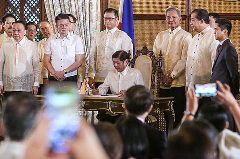 PRESIDENT Ferdinand Marcos Jr. signs the CREATE MORE Bill into law as lawmakers, led by Senate President Francis Escudero (fifth from left) and House Speaker Martin Romualdez (third from right), as well as top officials of the executive department, look on.
