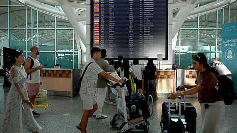 Passengers look at an electronic board displaying cancelled flights after the nearby Mount Lewotobi Laki-Laki volcano catapulted an ash tower miles into the sky, at the Ngurah Rai International Airport in Tuban near Denpasar, on Indonesia's resort island of Bali on 13 November 2024.