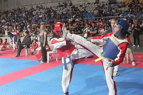 A player in a blue armor executes a head kick to her opponent during a previous sparring session supervised by the Philippine Taekwondo Association.
