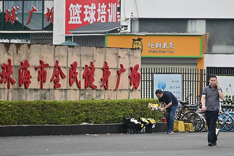Workers remove flowers from a makeshift memorial outside the Zhuhai Sports Center in Zhuhai in south China’s Guangdong province on 13 November 2024, two days after 35 people were killed when a man drove a car into a crowd in one of the country’s deadliest mass-casualty events in years.