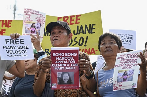 Cesar Veloso (L) and Celia Veloso (R), parents of Mary Jane Veloso, a Philippine drug convict in Indonesia, hold placards as they join a protest to appeal for clemency and to hand a new letter of appeal for her freedom, at Mendiola Street in Manila on 10 January, 2024.