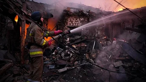 A Ukrainian rescuer works to extinguish a fire in a building following a drone attack in Mykolaiv.