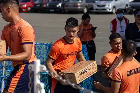 PCG members work together to load food packs onto BRP Teresa Magbanua