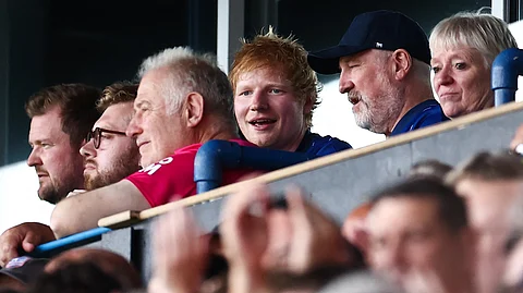 British singer Ed Sheeran (C) attends the English Premier League football match between Ipswich Town and Liverpool at Portman Road in Ipswich, eastern England on 17 August 2024.