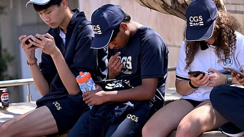 Students look at their phones in Australia, where the government has passed a law banning social media for those under 16