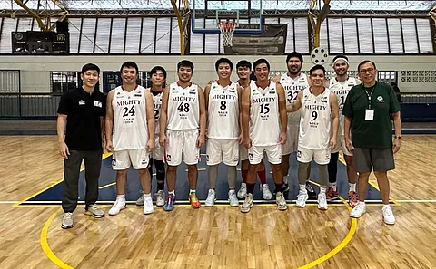Members of Mighty Sports, led by Caesar and Angelo Wongchuking, pose prior to a game in the Xavier Alumni Basketball League.