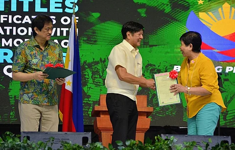 LOOK: President Ferdinand R. Marcos Jr. and DAR Secretary Conrado M. Estrella III hand over land titles to agrarian reform beneficiaries in Quezon.