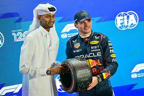 Red Bull Racing’s Max Verstappen (right) receives the pole position trophy from Qatar’s track and field athlete Mutaz Essa Barshim at the end of the qualifying session of the Qatari Formula One Grand Prix at the Lusail International Circuit in Lusail, Qatar.