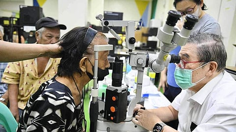DR. Antonio Say (right) examines a patient during a medical outreach in Dagupan City, Pangasinan.