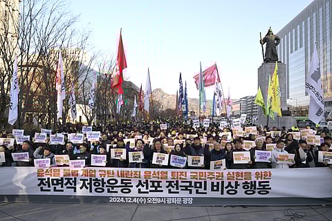 South Korean protesters hold a banner that read ‘we condemn Yoon Suk Yeol’s illegal martial law’ during a rally against President Yoon Suk Yeol at Gwanghwamun Square in Seoul on 4 December 2024, after martial law was lifted.