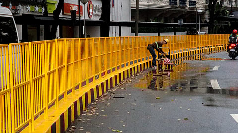 A worker inspects and secures the freshly painted center island along Paseo de Roxas in Makati City on December 4, 2024, preparing it for public use.