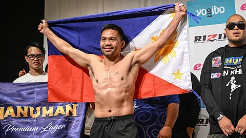 Philippine boxing legend Manny Pacquiao poses with the Philippines flag following the official weigh-in at a hotel in Tokyo on 27 July 2024 ahead of his 28 July three-round exhibition boxing match against Japanese mixed martial artist Rukiya Anpo.