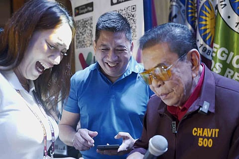 Senatorial candidate Luis ‘Manong Chavit’ Singson shows how VBank app works during his appearance at the Vice Mayors League of the Philippines assembly at the Diamond Hotel along Roxas Boulevard on Thursday. His VBank initiative, a digital platform, seeks to provide unbanked and underbanked Filipinos with easy access to financial services.