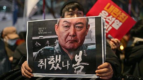 A protester holds a poster calling for the ouster of South Korean President Yoon Suk Yeol at a candlelight rally in Seoul