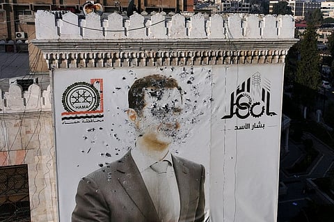This aerial picture shows a bullet-riddled portrait of Syrian President Bashar al-Assad adorning Hama's municipality building after it was defaced following the capture of the city by anti government fighters, on 6 December, 2024. Rebel forces pressing a lightning offensive in Syria aim to overthrow President Bashar al-Assad's rule, their Islamist leader said in an interview published on December 6. In little over a week, the offensive has seen Syria's second city Aleppo and strategically located Hama fall from Assad's control for the first time since the civil war began in 2011.