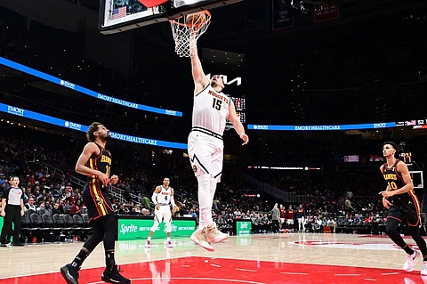 ATLANTA, GA - 8 DECEMBER: Nikola Jokic #15 of the Denver Nuggets dunks the ball during the game against the Atlanta Hawks at State Farm Arena in Atlanta, Georgia.