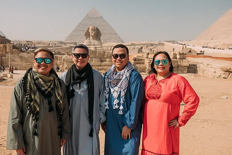 The author wears an abaya while her companions wear galabeyas which are traditional flowing tunics.