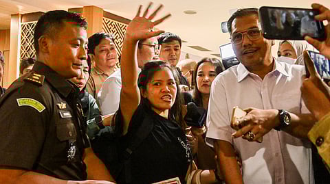 Filipina inmate on Indonesia death row, Mary Jane Veloso (C) waves as she is repatriated to the Philippines after a press conference at the Soekarno-Hatta International Airport in Tangerang on 17 December 2024. A Filipina inmate sentenced to death in Indonesia was moved to capital Jakarta before she is expected to fly home on 18 December, after the government signed an agreement to repatriate her.