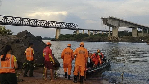 This handout photo released by Tocantins Fire Department shows firefighters during a rescue operation after the Juscelino Kubitschek de Oliveira bridge connecting Tocantins and Maranhao fell on 22 December 2024 over the Tocantins river at the city of Aguiarnopolis, Tocantins state, Brazil.