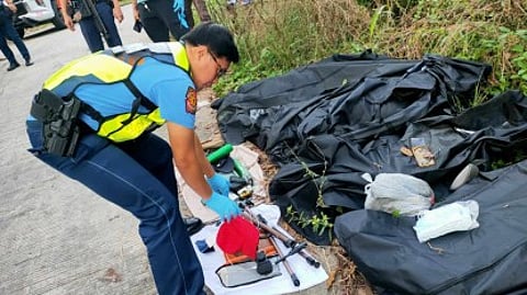 FATAL CRASH. A police investigator in Tupi, South Cotabato, examines the belongings of road accident victims who died after their van hit a tree on Monday (23 Dec. 2024). Six of the seven fatalities were residents of Barangay Bugo, Cagayan de Oro City.