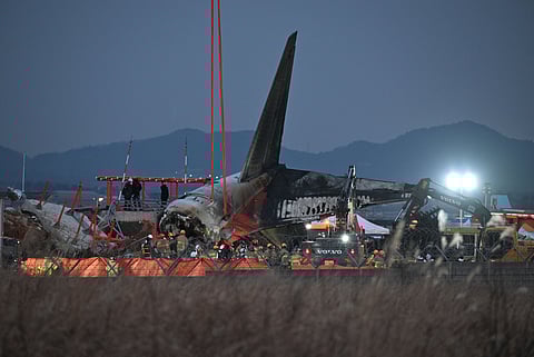 (FILE) Firefighters and rescue personnel work near the scene where a Jeju Air Boeing 737-800 series aircraft crashed and burst into flames at Muan International Airport in South Jeolla Province, some 288 kilometers southwest of Seoul on 29 December 2024. A Jeju Air plane carrying 181 people from Thailand to South Korea crashed on arrival, smashing into a barrier and bursting into flames, leaving all but two feared dead.