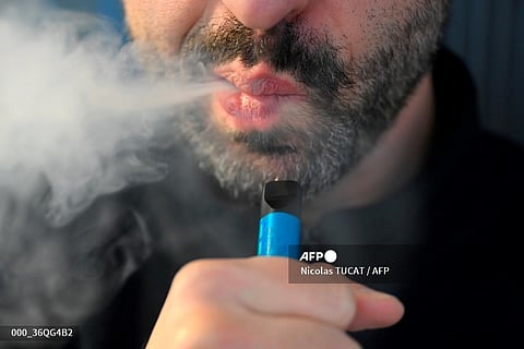 A man smokes a disposable electronic cigarette in Brussels on December 12, 2024. Belgium will ban the sale of disposable e-cigarettes (also known as 'vapes') from 1 January 2025, as it received approval from the European Commission to do so.
