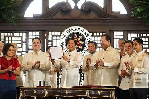President Ferdinand R. Marcos Jr. shows the signed copy of Republic Act 11954 or the Maharlika Investment Fund Act of 2023, at the Kalayaan Hall of Malacañang Palace with Senate and House leaders.