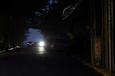 The headlights of a car lights up a dark street in San Juan, Puerto Rico after a major power outage hit the island on 31 December, 2024. A major power outage plunged much of Puerto Rico into darkness Tuesday, with the US island territory's electric utility saying restoration could take up to two days. The "island-wide blackout" began at 5:30 am (0930 GMT), Luma Energy said in a social media statement.