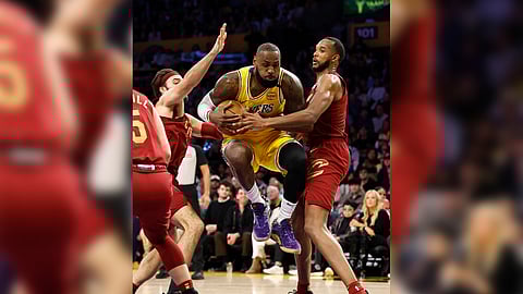 Lebron James of the Los Angeles Lakers struggles against the Cleveland Cavaliers defense during their 110-122 loss in the NBA regular season.